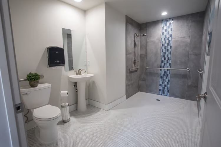 Accessible bathroom with a barrier-free walk-in shower and grab bars at McCormick Ranch Assisted Living